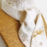 White embroidered honey toned silk stock pre tied with gold horse's head stock pin